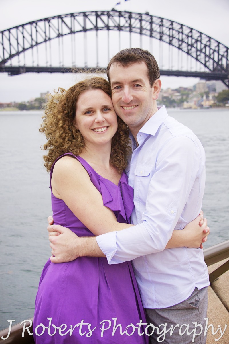 Portrait of a couple in front of Sydney Harbour Bridge - engagement photography sydney